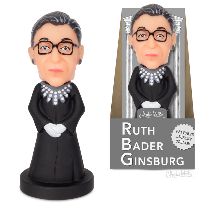 Ruth Bader Ginsburg nodder figurine in black robe with distinctive collar, glasses, and styled hair. Packaging shows Supreme Court columns and product features. Collectible vinyl figure of iconic justice, 5 inches tall.