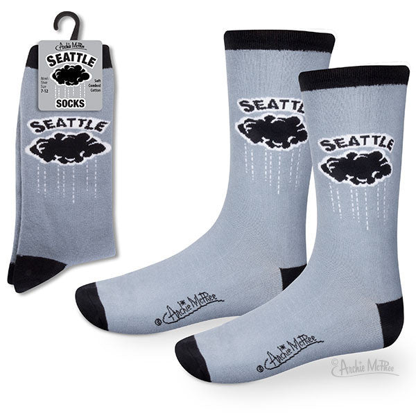 Light blue socks with black trim featuring Seattle rain cloud design, displayed on packaging and as worn. Product showcases Seattle-themed comfort wear for everyday use and rainy weather.