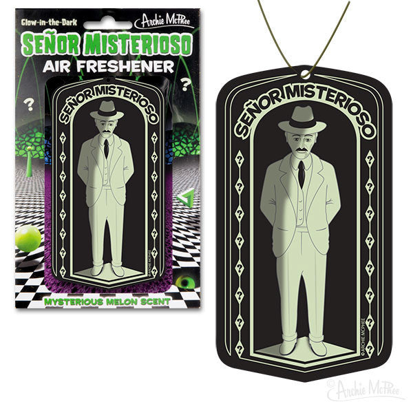 Glow-in-the-dark Señor Misterioso Air Freshener packaging and product image, featuring a mysterious figure in a suit and hat. The design showcases both the retail packaging and the actual air freshener with a vintage-inspired illustration on a black background.