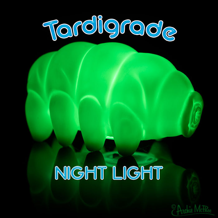 Glowing green ceramic tardigrade night light against a dark background, with blue text reading "Tardigrade Night Light