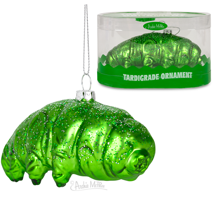 Glittery green glass tardigrade Christmas ornament, 4.5 inches long, with hanging string. Displayed both inside packaging and as standalone item. Unique holiday decoration inspired by microscopic water bears.