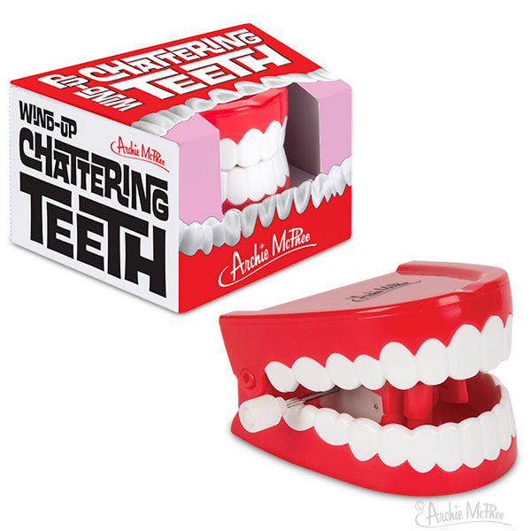 Wind-up chattering teeth novelty toy with red and white plastic dentures, displayed next to its colorful retail box featuring bold text and playful graphics, perfect for gags and pranks